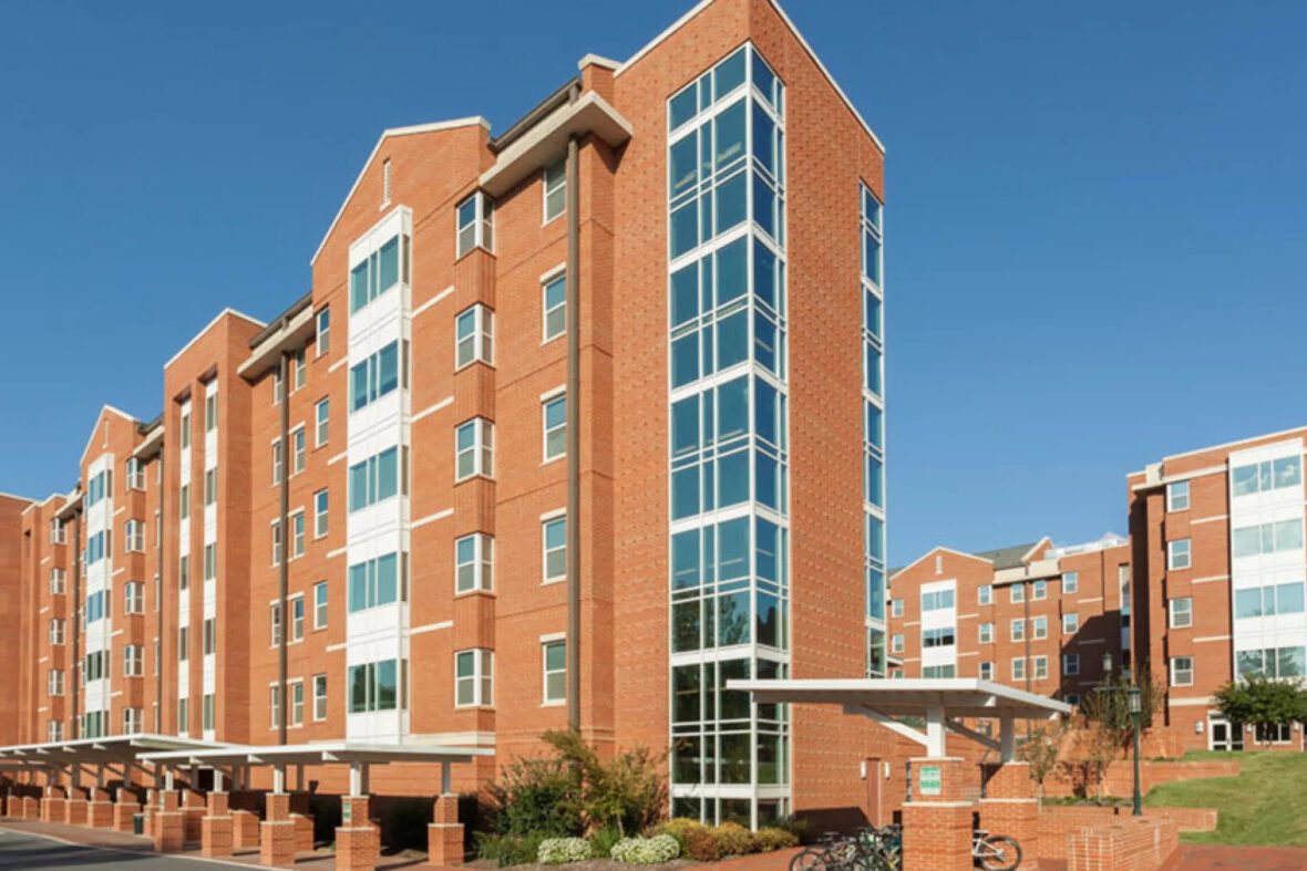 Brick residential buildings with large windows and white accents under a blue sky.