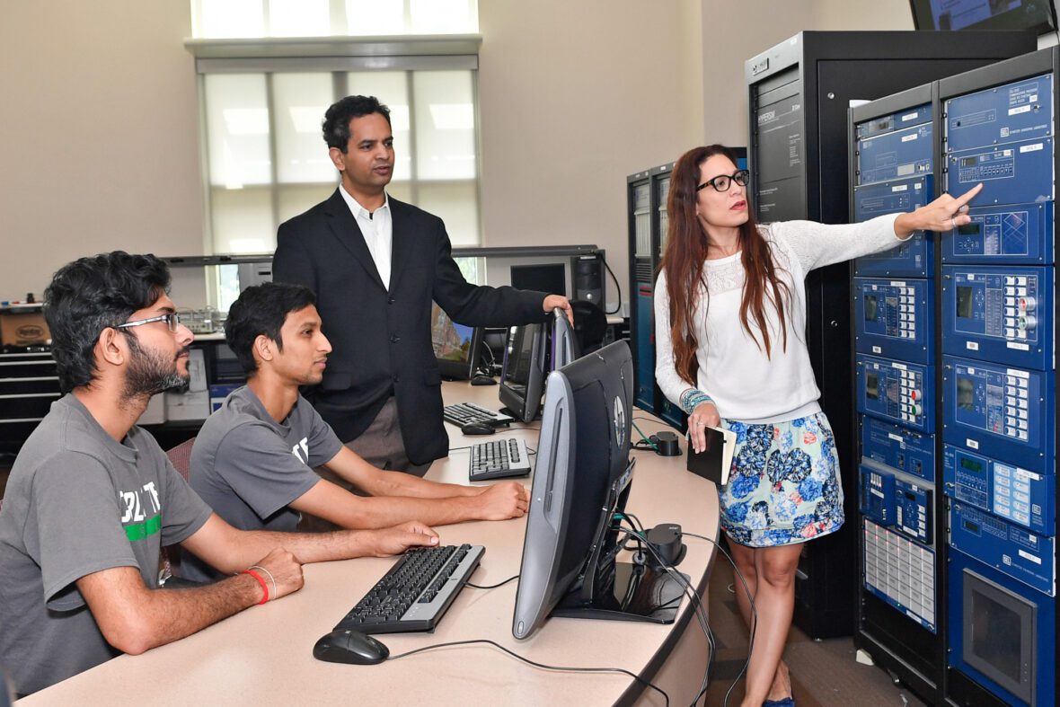 Professors teaching students about technical equipment in a lab