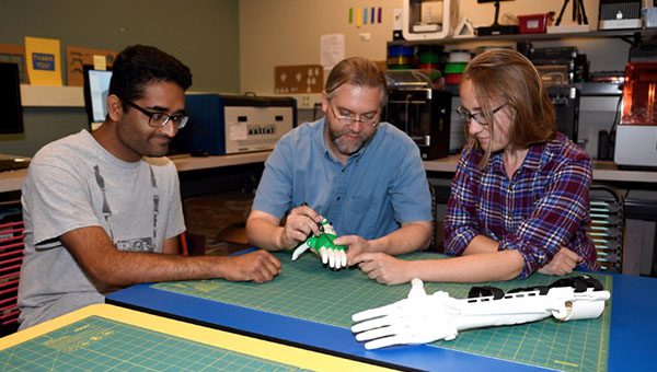 3 faculty members working on robotic arms