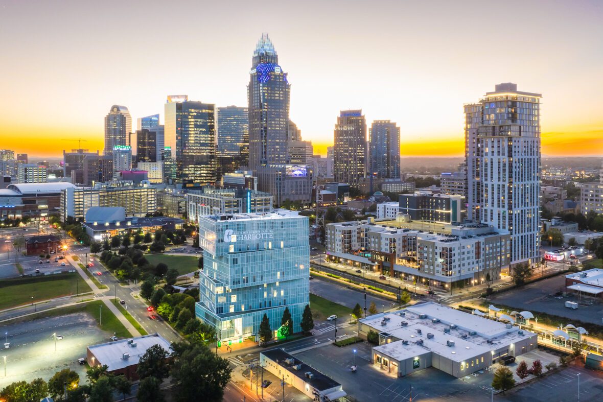 UNC Charlotte Dubois Center in Uptown Charlotte with Charlotte skyline in the background at sunrise