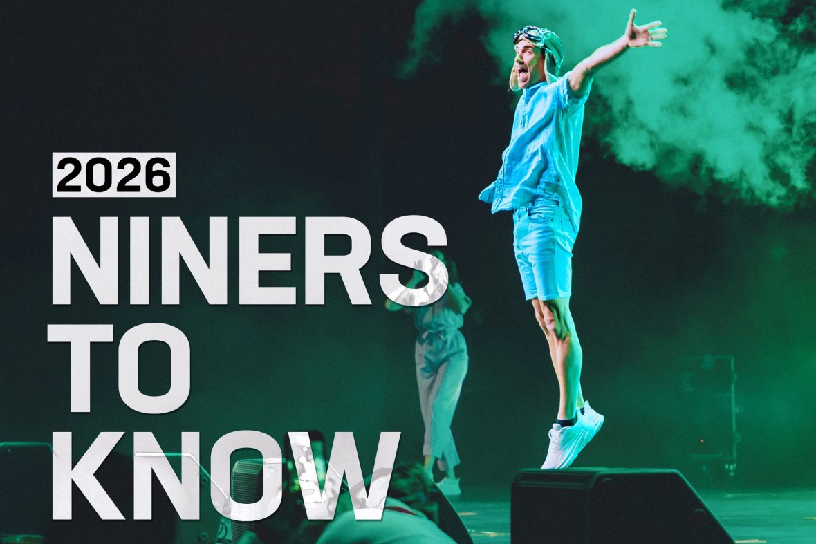 Promotional graphic for “2026 Niners to Know” featuring a performer mid-jump on a stage with arms outstretched, wearing a vintage aviator-style cap and goggles. Green stage lighting and theatrical smoke fill the background, while large white text reads “2026 Niners to Know.”
